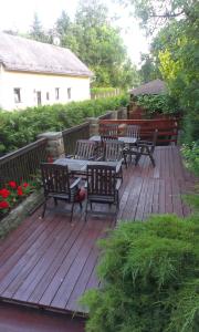 una terraza de madera con bancos y mesas. en Pension Doctor, en Dvůr Králové nad Labem