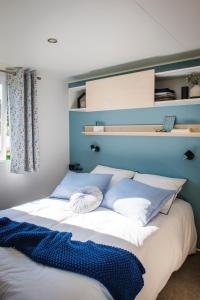 Una cama con almohadas azules y blancas. en Lake Park, en Berlare