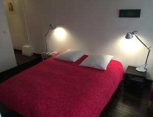 a bedroom with a red bed with two white pillows at Chambre d'Hôtes Annelets in Paris