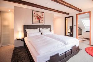 a bedroom with a large bed with white sheets at Landhaus Alte Apotheke in Großefehn 