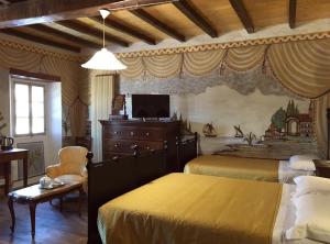 a bedroom with two beds and a tv on the wall at B&B Antico Mulino in Camugnano