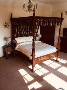 a bedroom with a wooden bed with a canopy at Brass Castle Country House Accommodation in Middlesbrough