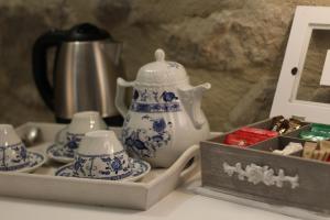 un set de té con una tetera y tazas en una mesa en B&B Antico Mulino en Camugnano