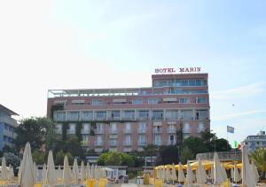 a hotel with a sign on top of a building at Grande Albergo Marin in Lignano Sabbiadoro