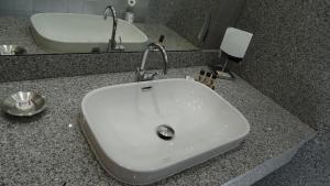 a bathroom with a white sink and a mirror at Résidence Saint Michel in LʼÎle-Rousse