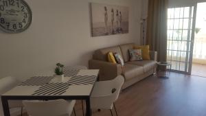 a living room with a couch and a table and chairs at Sky Loft Tenerife in Palm-Mar