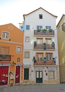een wit gebouw met balkons in een straat bij Casas de Fado in Lissabon