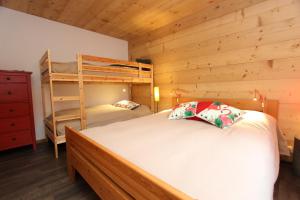 a bedroom with two bunk beds and a ladder at Les Erables in Chateau-d'Oex