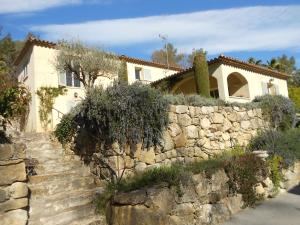 a stone retaining wall in front of a house at Le Mas de FRAYERE in Le Rouret