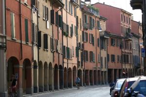 a person riding a bike down a street with buildings at Studio Apartment Santa Caterina in Bologna