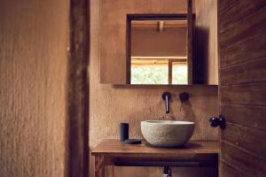 a bathroom with a bowl sink and a mirror at Andenia Boutique Hotel in Urubamba