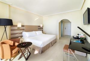 a hotel room with a bed and a desk and a tv at H10 Gran Tinerfe - Adults Only in Adeje