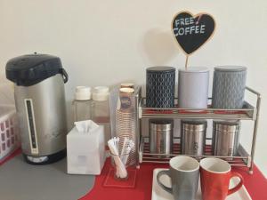 a shelf with coffee cups and a coffee maker on a counter at Honghub Sakon Hotel in Sakon Nakhon