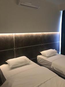 2 Betten mit weißen Kissen in einem Zimmer in der Unterkunft Hotel Grand in Sarajevo