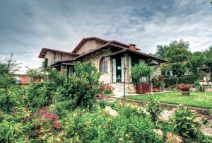 una casa con un jardín delante de ella en B&B Villa Garden en Saturnia