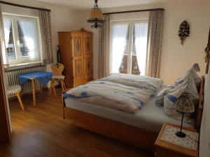 Un dormitorio con una cama, una cómoda y ventanas. en Haus Rita, en Mittenwald