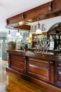 Riverbank, Country Pub and Guesthouse في كاريكماكروس: بار مع كونتر خشبي كبير