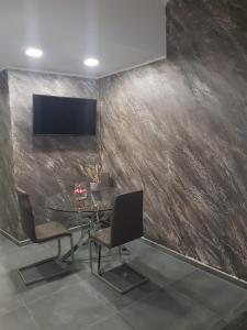 a dining room with a table and a tv on a wall at Home Suite in Catania