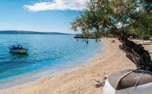 - un bateau sur une plage de sable au bord de l'eau dans l'établissement Palmaja, à Kaštela