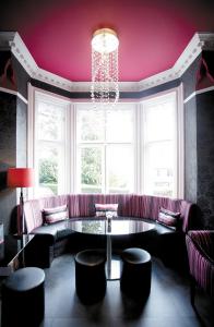 a living room with a couch and a chandelier at Cotford Hotel in Great Malvern