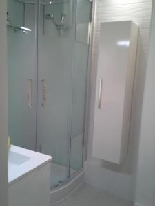 a white bathroom with a shower and a sink at Résidence Le poisson d'or in Perros-Guirec