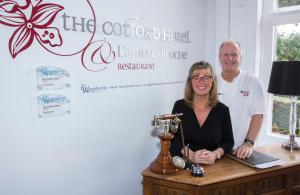 Un homme et une femme debout à côté d'une table dans l'établissement Cotford Hotel, à Great Malvern