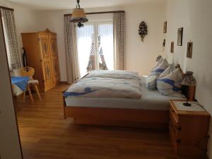 Un dormitorio con una cama con almohadas azules y una ventana. en Haus Rita, en Mittenwald