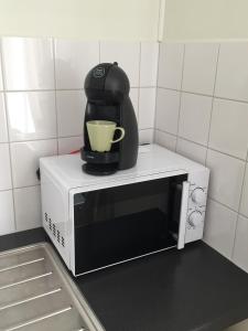 a coffee maker sitting on top of a microwave at The Green House Guesthouse in Sunnemo