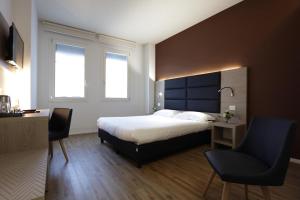 a bedroom with a bed and a desk and two chairs at Letto A Castello in Ferrara
