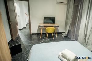 ハルキスにあるExplore Greece from Bright City Centre Apartmentのベッドルーム1室(デスク、ベッド1台、黄色い椅子付)