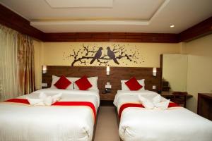 a hotel room with two beds with red pillows at Hotel Splendid View in Pokhara