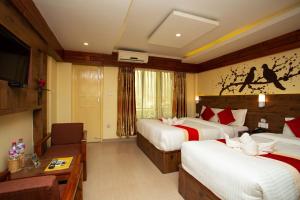 a hotel room with two beds and a television at Hotel Splendid View in Pokhara