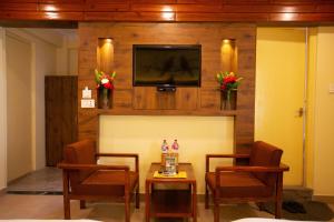 a living room with two chairs and a table and a tv at Hotel Splendid View in Pokhara