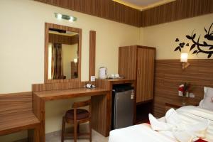 a bedroom with a desk and a bed and a mirror at Hotel Splendid View in Pokhara