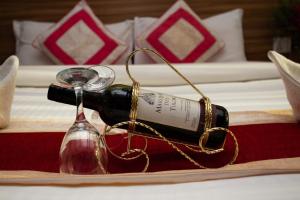 a bottle of wine and a glass on a bed at Hotel Splendid View in Pokhara