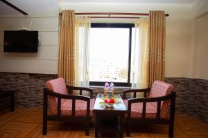 a dining room with a table and chairs and a window at Hotel Splendid View in Pokhara