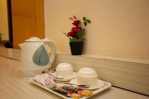 a tea kettle and cups on a table with a plate of food at Hotel Splendid View in Pokhara