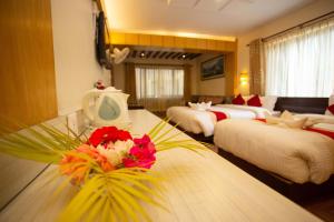 a hotel room with four beds and a table with flowers at Hotel Splendid View in Pokhara