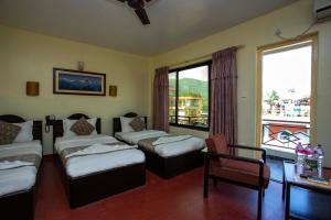 una camera con tre letti e un tavolo e una finestra di Hotel Splendid View a Pokhara