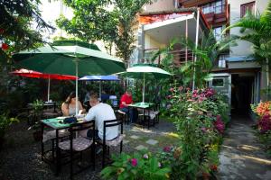 a group of people sitting at tables under umbrellas at Hotel Splendid View in Pokhara