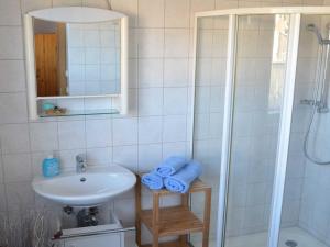 a bathroom with a sink and a shower with blue towels at Ferienwohnungen Chris Stephan in Oberweißbach