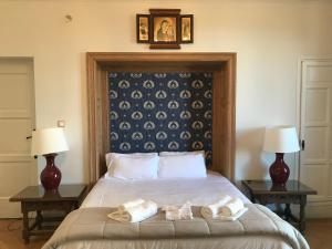 1 dormitorio con 1 cama con toallas en Hospedería Santa Cruz, en San Lorenzo de El Escorial