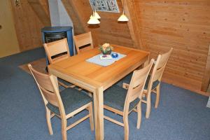 a wooden table with chairs and a vase of flowers on it at Urlaub fuer die ganze Familie in Damp