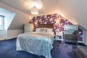 a bedroom with a large bed with a purple wall at Shorehead Guest House in Stonehaven