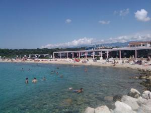 a group of people in the water at a beach at Apartmani Vuković in Gajac