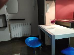 a kitchen with a blue stool and a glass of wine at Apartamentos Deluxe Barajas in Madrid +55 photos