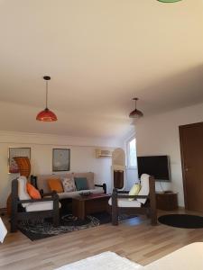Hotel Kika في بريشتيني: غرفة معيشة مع أريكة وتلفزيون