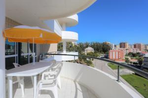 a balcony with a table and chairs and an umbrella at Sotto Mayor Residence in Figueira da Foz