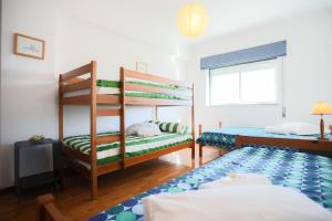 a bedroom with two bunk beds and a window at Sotto Mayor Residence in Figueira da Foz