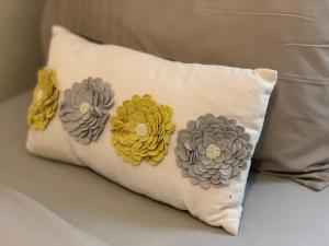 ein Kissen mit Blumen auf dem Bett in der Unterkunft Cosy Corner House in Kettering